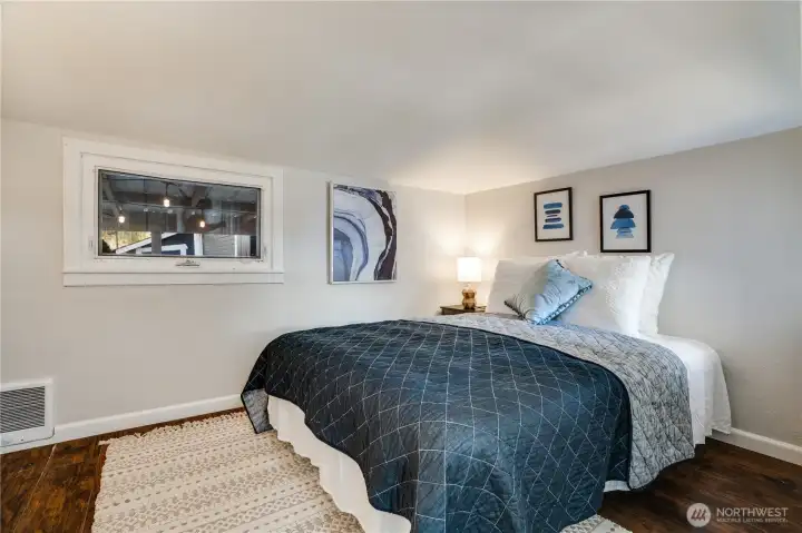 The primary bedroom features a spacious layout, bright windows, and room for dressers and added storage.
