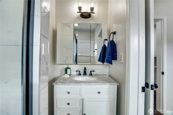 Fresh finishes and thoughtful details—this updated vanity features a quartz countertop, stylish lighting, and a medicine cabinet that keeps essentials close.