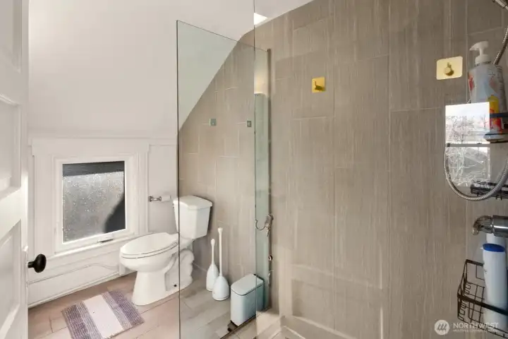 Unit #2015: Updated bathroom with fresh tile and glass shower surround.