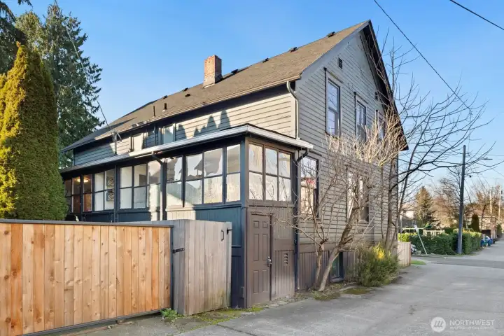 Corner lot with alley access - this shot shows the rear of Unit #2015, with external door and gated (gray fence) access to the yard. (The bright wood gate is part of neighboring property.)