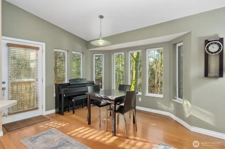 Sun-drenched curved dining nook framed by nature.