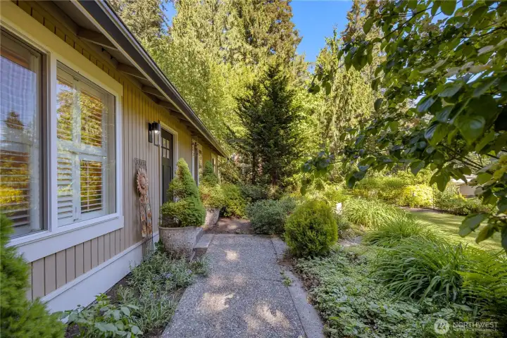 A lush garden path leads to the home’s gently sheltered entry, with only one step up to the front door. So much care has been taken to refresh the beautiful gardens. A pebbled path leads you to your Craftsman inspired freshly painted front door with new handle, lit by a lovely caged lantern.
