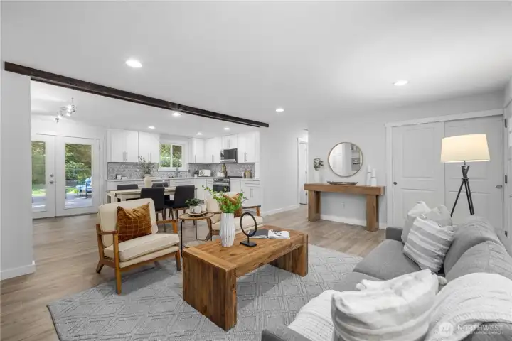 The open-concept layout keeps the living, dining, and kitchen spaces connected in an easy, welcoming flow, while the exposed ceiling beam defines each area in a beautifully decorative way. A large hall closet adds practical storage for coats through many seasons, blending everyday function with the home’s clean, refreshed style.
