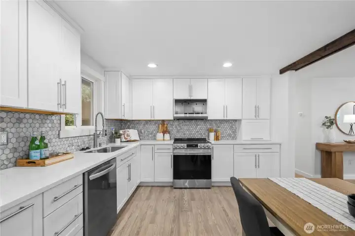 Quartz counters and a high hexagon tile backsplash give the kitchen a clean, polished look, with backsplash tones that echo the living room fireplace for a cohesive feel.