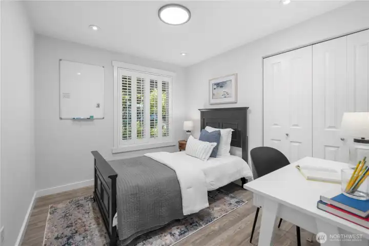The first bedroom on the right feels bright and versatile, with a south-facing window that catches a soft evening glow through the classic shutters. A large closet adds easy storage, luxury laminate hardwood matches any decor, while the new modern flush-mount ceiling light plus recessed lighting provides clean, even lighting.The first bedroom on the right feels bright and versatile, with a south-facing window that catches a soft evening glow through the classic shutters. A large closet adds easy storage, while the new modern flush-mount ceiling light provides clean, even lighting for a bedroom, office, or creative space.