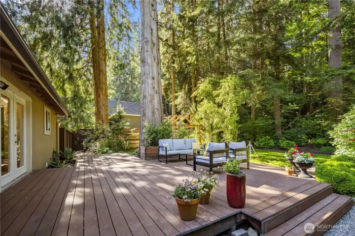 Step out onto the gorgeous Trex deck which spans the length of the home, creating a beautiful outdoor living space with room to gather, dine, and relax in the garden setting. Surrounded by mature evergreens, layered plantings, and shifting pockets of sun and shade, the deck extends the home’s nature-retreat feeling into everyday outdoor living.