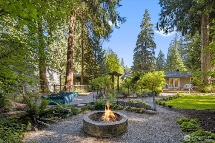 A circular path curves around the privacy wall, inviting an easy wander through the garden. Follow it past raised garden beds and trees and lined with deliberate plantings, with each turn revealing another thoughtful layer of this peaceful backyard retreat.