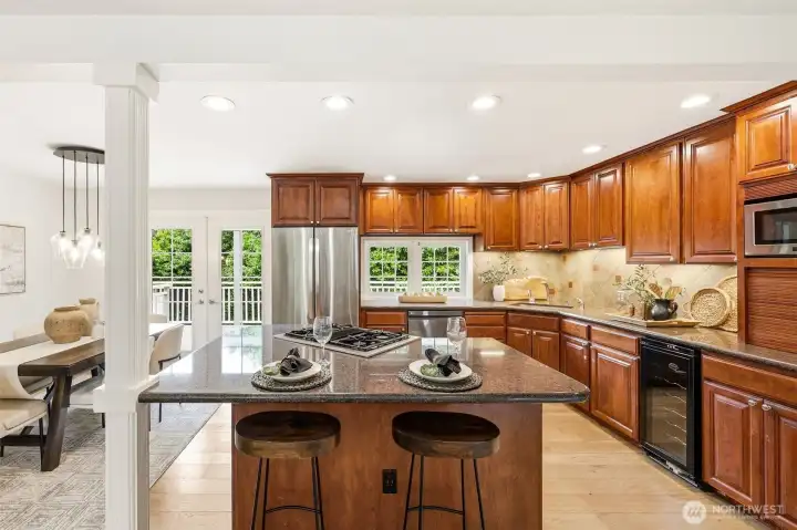 The kitchen island with gas cooktop and bar seating opens seamlessly to the dining area and deck — ideal for everyday living and entertaining. The kitchen island with gas cooktop and bar seating opens seamlessly to the dining area and deck — ideal for everyday living and entertaining.