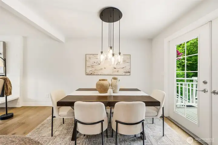 The dining room features a striking pendant light fixture, hardwood floors, and French doors that open directly to the back deck. The dining room features a striking pendant light fixture, hardwood floors, and French doors that open directly to the back deck.