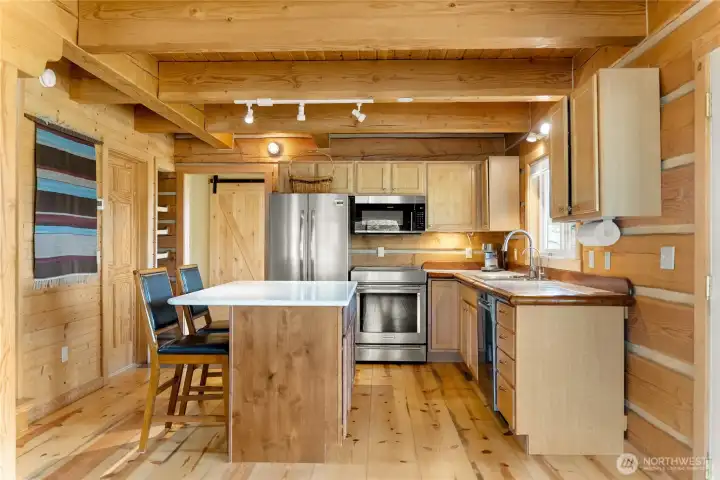 Center island kitchen with induction range, custom cabinetry & newer appliances.