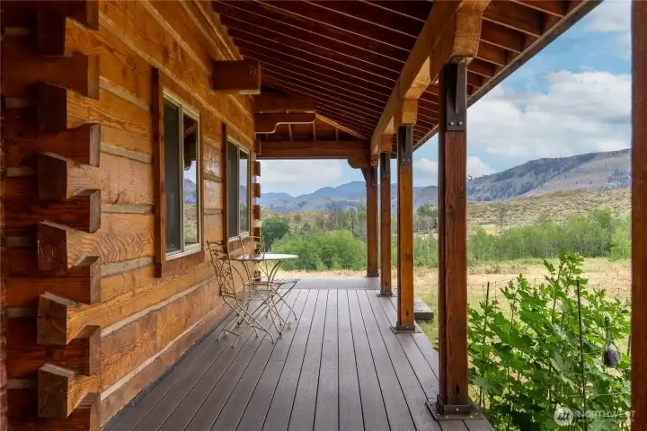 West side covered porch framed by attractive stacked-log construction.