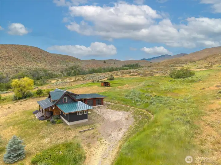Aerial view showcasing the home, privacy & surrounding mountain landscape.
