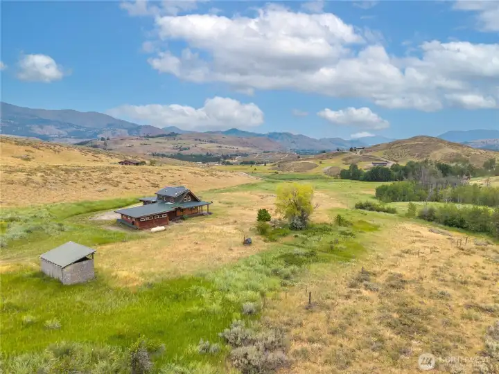 Bird's-eye view of the home, garage & surrounding mountain scenery.