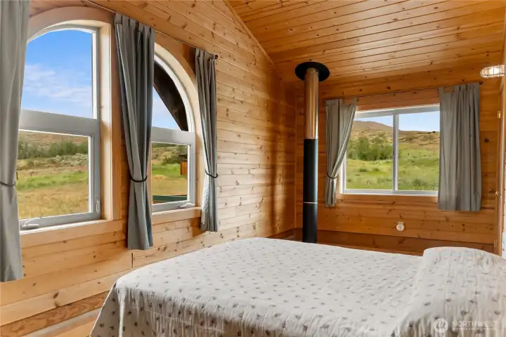 Cozy guest bedroom with vaulted wood ceilings.  viewiing west towards the sunset.