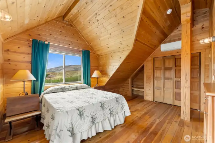 Spacious upper primary bedroom filled with natural light.