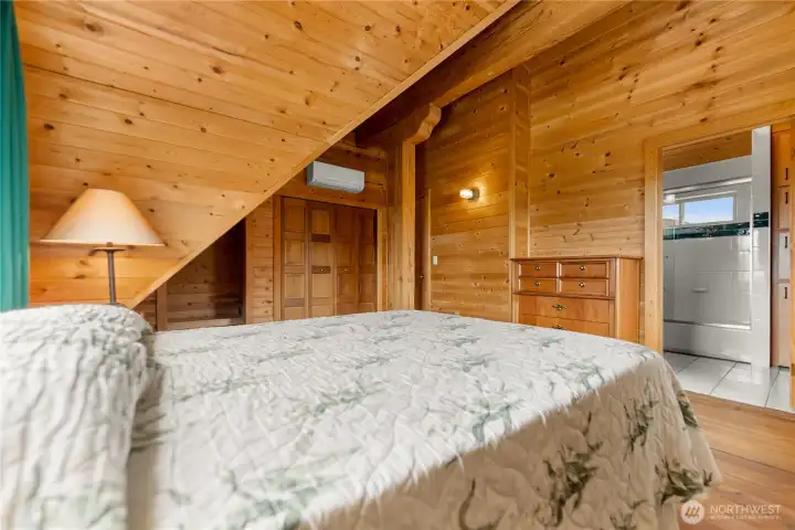 Private primary suite with warm wood finishes, vaulted ceilings & ensuite bath.