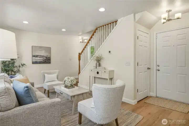 Living room with front entrance door on the right. Water heater and furnace access is in the closet is just to the left under the stairs