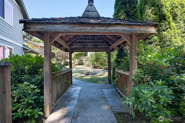 Charming gazebo leads from the garage to the common area