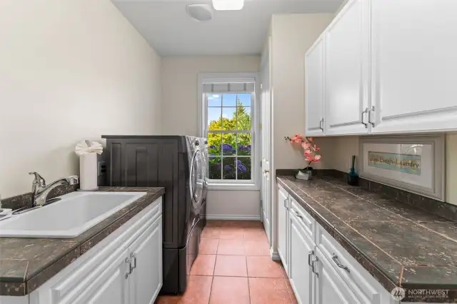 Wonderful laundry/mud room between the oversized three car garage and the kitchen/family room area of this home. Just to the right of this is another room with a bench and shoe/boot storage.