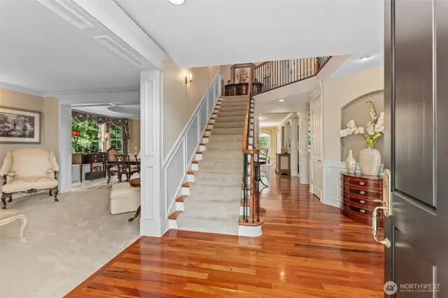 Grand staircase with beautiful iron balusters and wainscoting, rising up from stunning cherry hardwood main floor. A second stairway from the family room side of the home is also provided.