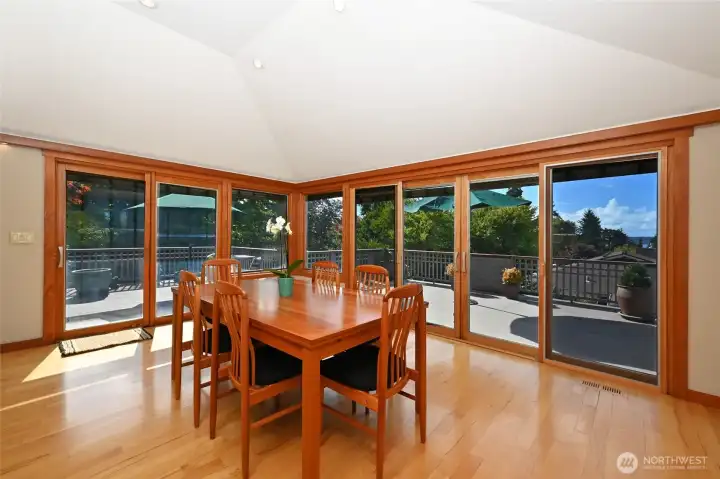 Remodeled dining room with vaulted ceiling and recessed lighting. Pella wood wrapped sliding doors and window out to the deck.