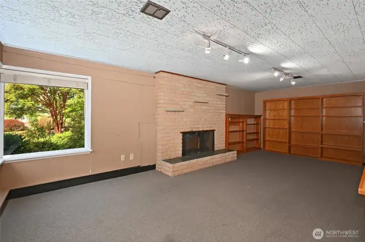 Lower level rec room. High ceilings and fireplace.