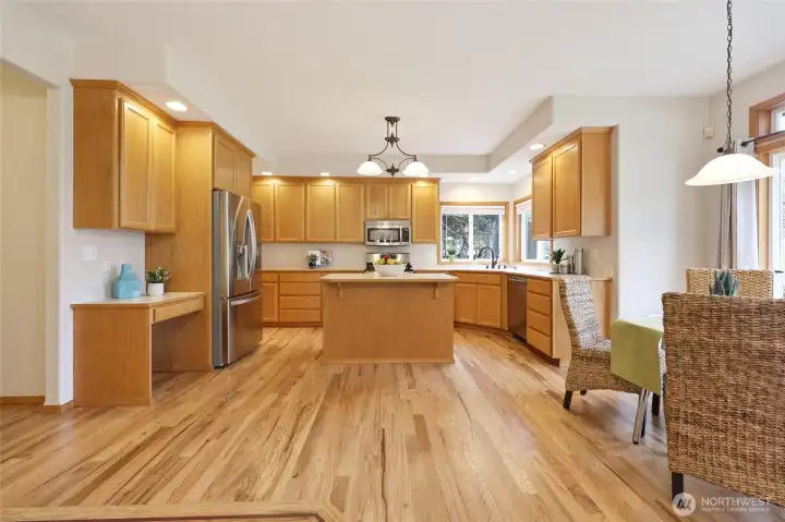 Look at all this space!! And there's still a butler's pantry?! Gorgeous hardwood floors shine in this space! Built in desk on the left side adds a convenient storage spot, homework space, etc.! Breakfast nook on the right sits in front of sliding glass doors leading to the backyard patio.