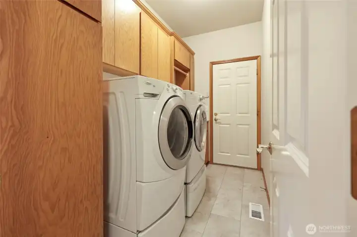 Laundry room with so much storage! Large utility sink located on the other side of the washer. Washer and dryer included in the sale! Door leads to the 3-car garage.