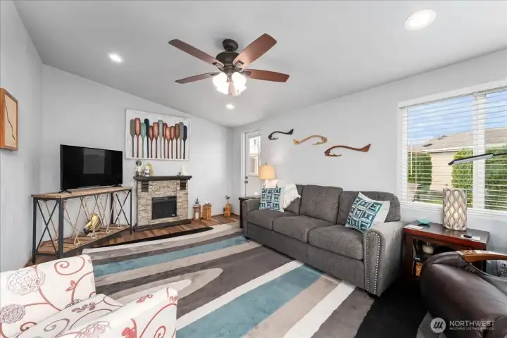 Another view of living room with furnishings and ceiling fan