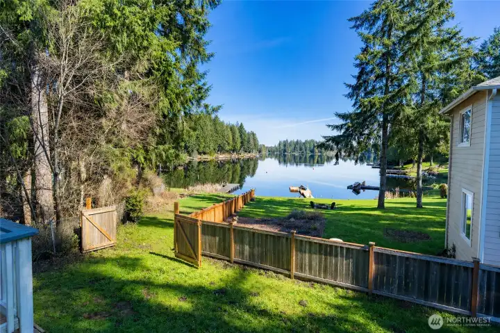 Backyard with access to private dock and lake. This image was virtually staged to open the gate. The gate does open.