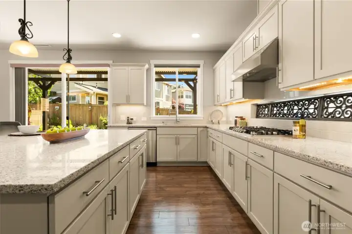 Chef’s dream kitchen offering ample storage and workspace in a light filled setting, with white cabinets and quartz countertops