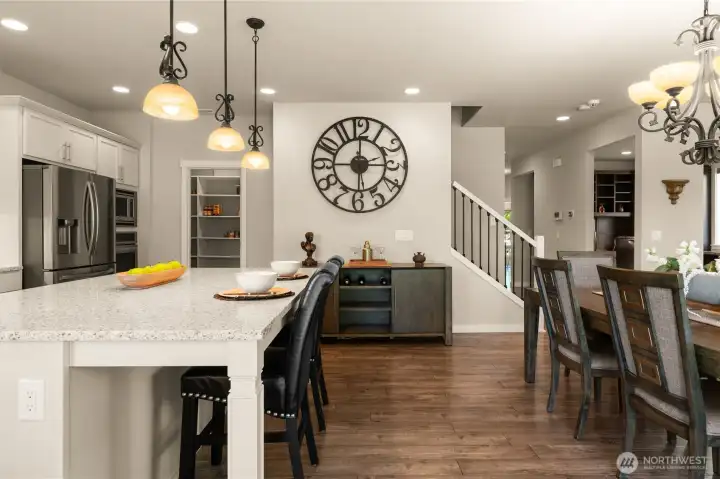 Spacious walk-in pantry at the far end of the kitchen features custom built-ins, offering extra storage for groceries, cookware, and kitchen essentials