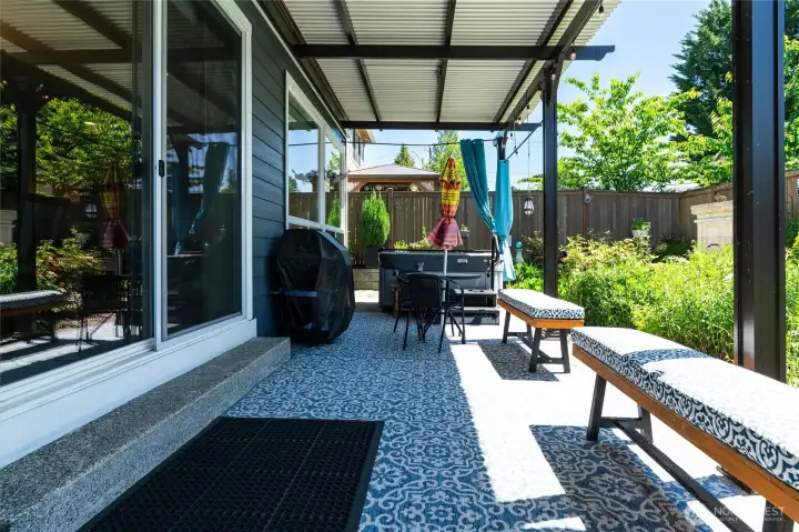 Expansive outdoor living area with automatic custom louvered roof and hot tub offering year-round outdoor enjoyment