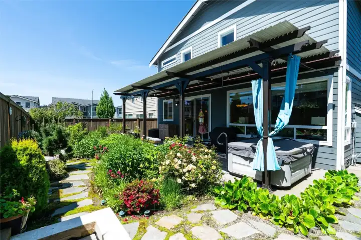 Lush flower beds and pavered walkways offer an English garden-feel to the mature garden area offering an array of colorful flowering plants
