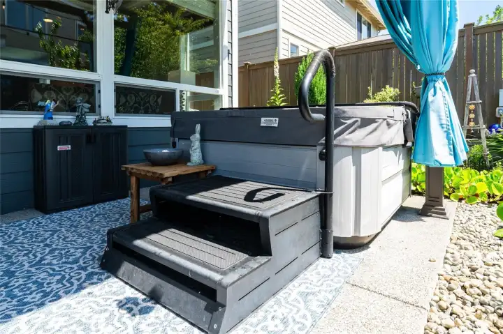 A place to unwind at the end of the day, in this private Jacuzzi hot tub appointed with privacy curtains and covered awning