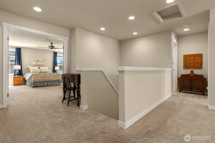 The half-wall stairway and open hallways foster a sense of connection and unity between the upper and lower levels