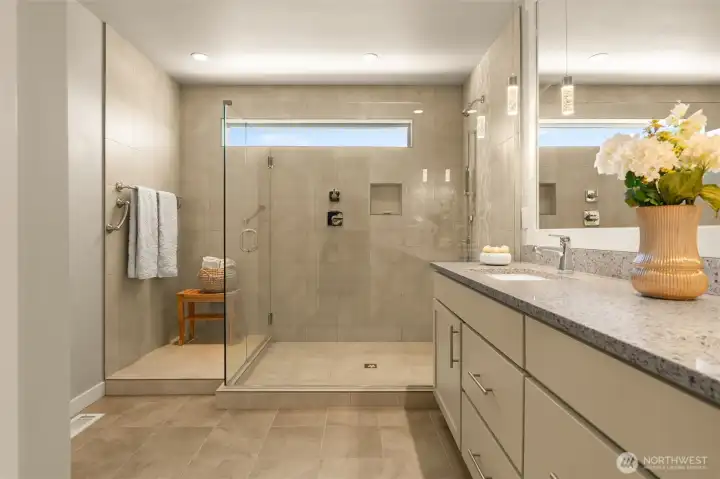 A generous, tiled walk-in shower offering space for a bench, for a luxurious shower/spa experience