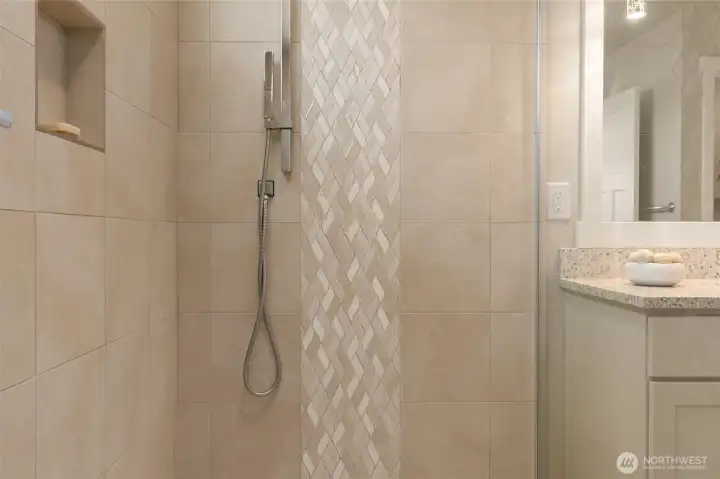 Intricate accent tile detail offers a sense of style and sophistication in the primary walk-in shower