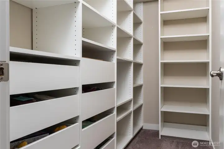 Thoughtfully designed to maximize storage, this secondary bedroom's walk-in closet provides custom drawers and shelving