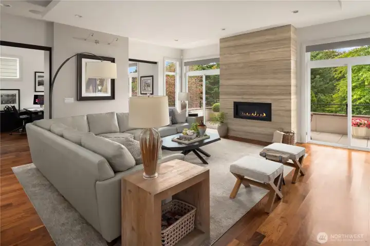 The living room features floor-to-ceiling Italian  silver travertine marble surrounding the welcoming fireplace.