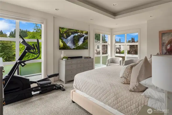 Primary bedroom features coffered ceilings, abundant lighting and a private deck