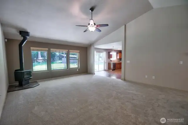 Large, light-filled living room with wood-burning stove.
