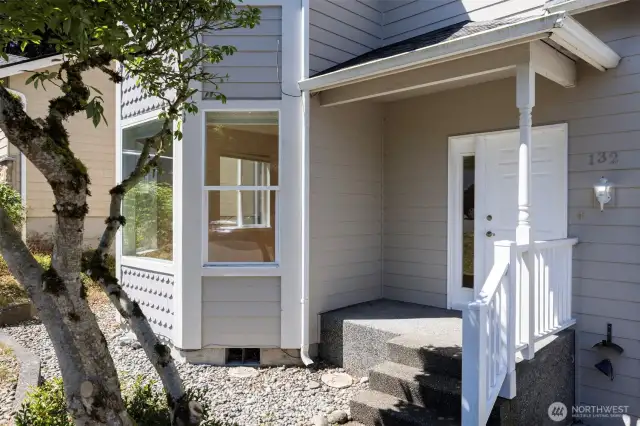 There is a welcoming aggregate front porch with room for a chair.