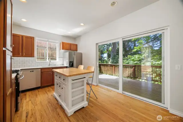 Another view of the kitchen with the island and the large sliding glass door that opens onto the large deck.