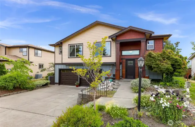 The home’s curb appeal shines with a blend of modern and natural textures—contrasting siding, stone accents, and mature landscaping frame this welcoming Birch Bay residence with a two-car garage.