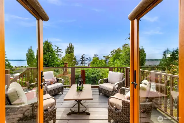 French doors from the living room lead directly to this intimate deck setting, where the scent of sea air and filtered sunshine create a true extension of the living space. Ideal for entertaining or relaxing in nature.