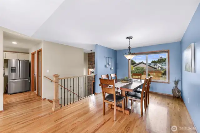 This alternate dining room perspective highlights architectural details like wrought-iron stair railings and wood trim, blending warmth with elegance and guiding the eye through the home’s fluid floor plan.