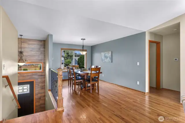 Large windows frame this bright dining area, offering peaceful neighborhood views and an inviting backdrop for morning coffee or dinner parties.