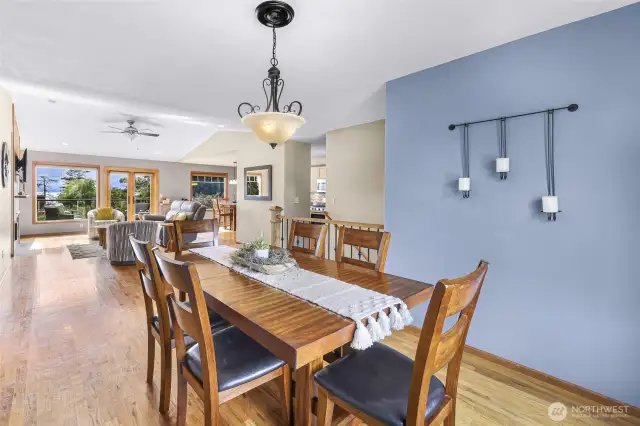 The dining area exudes character with its striking blue accent wall, statement chandelier, and natural wood finishes. Positioned between the kitchen and living space, it’s ideal for everyday meals or weekend gatherings.
