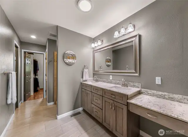 Thoughtfully designed for comfort, the en suite primary bath includes dual sinks with marble-look countertops, stylish mirrors, and custom cabinetry—offering a spa-like daily routine.